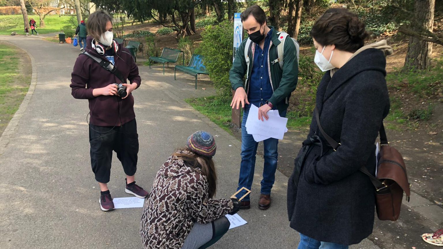 A photo of me and the other designers conducting a real-life playtest of the early concept in a park nearby